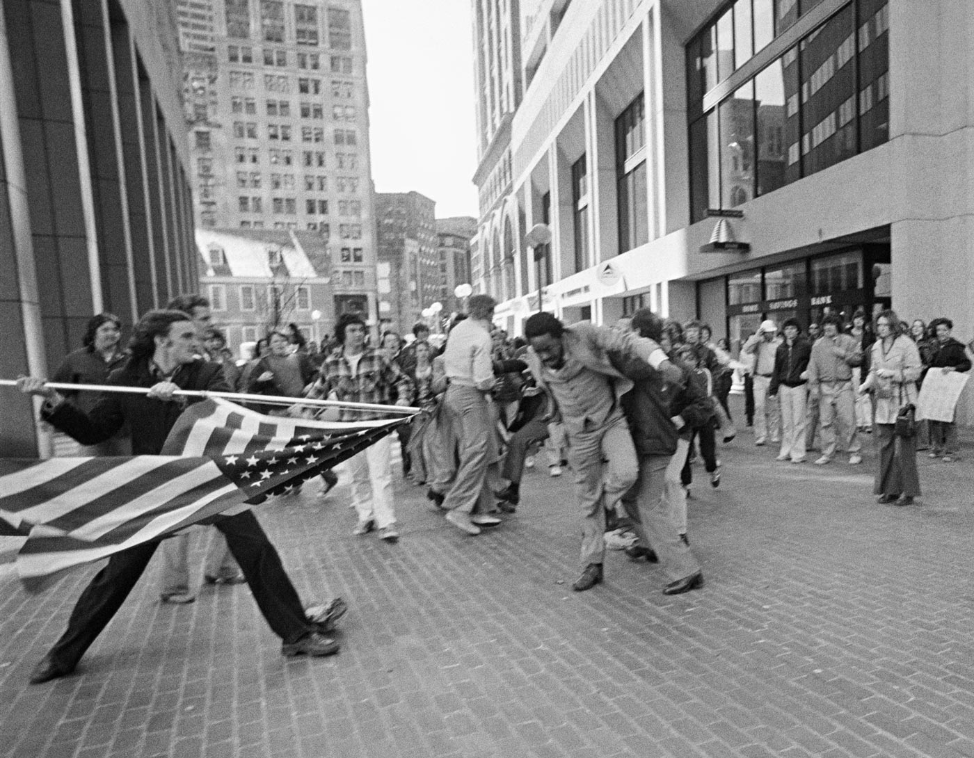 White protestor threatens African American passerby with flag